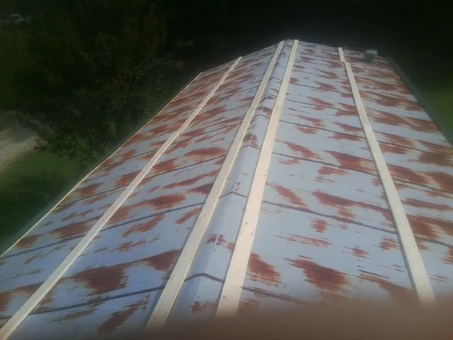 Rusted metal roof panels with new wood purlins before replacement — Storm Damage Roof Repair in Kingsburg by Roofing Brothers