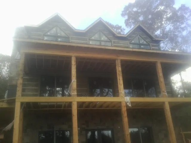 Dormers and porch framing on a large log home under construction — Roof Coating work by our crew in Kingsburg